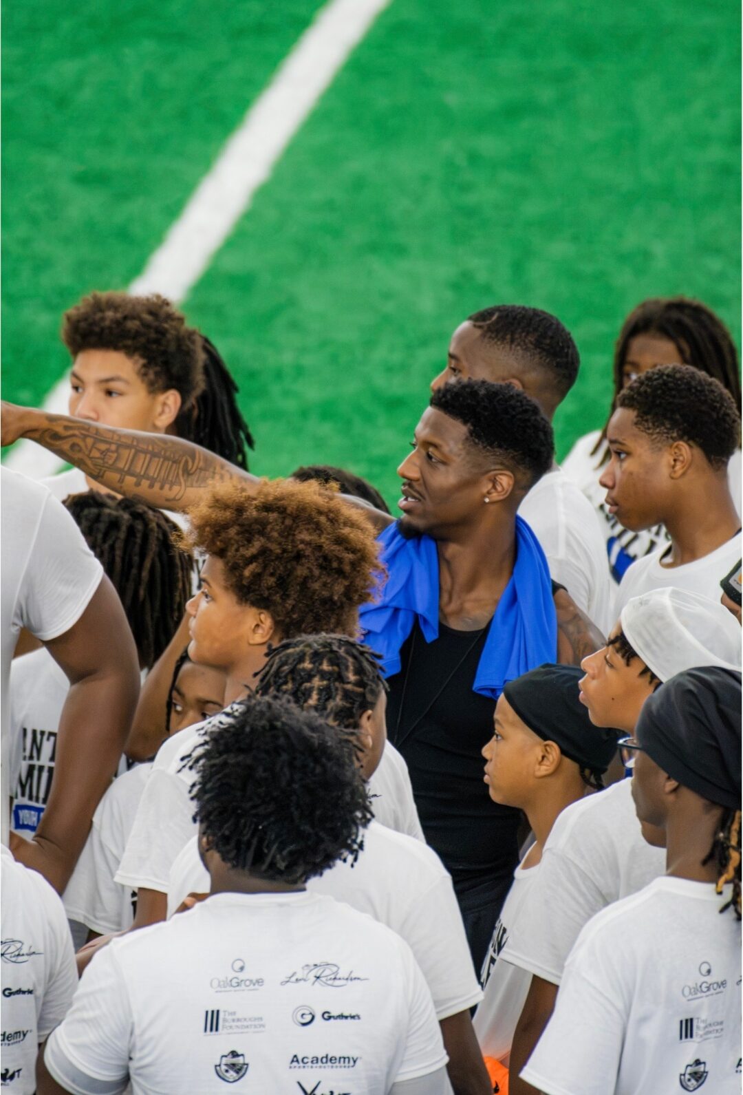 Anthony Miller II standing among a group of campers on the field