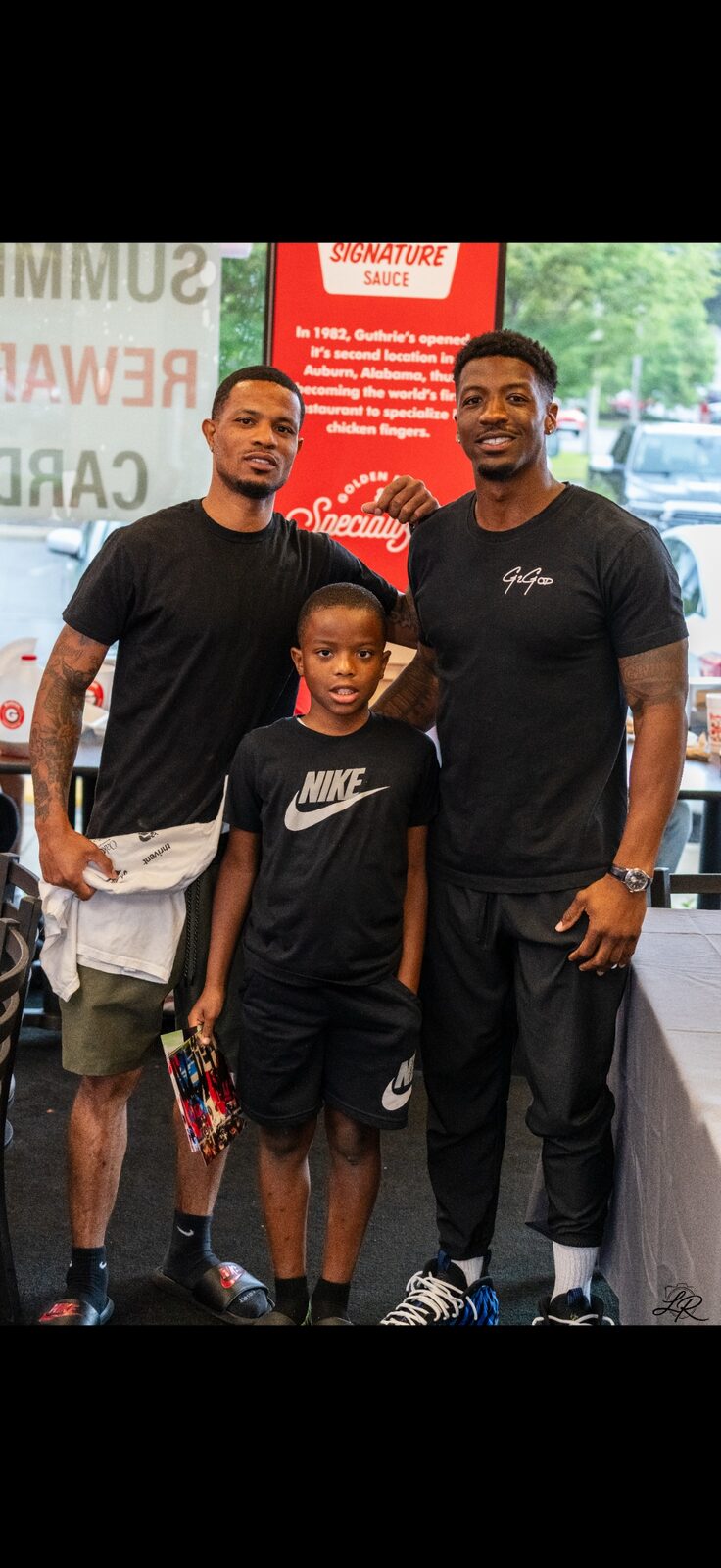 Anthony Miller II with a camper at a back-to-school signing table