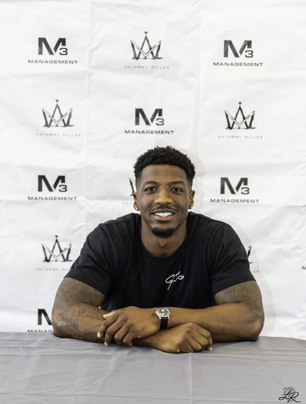 Anthony Miller seated at the autograph signing table smiling
